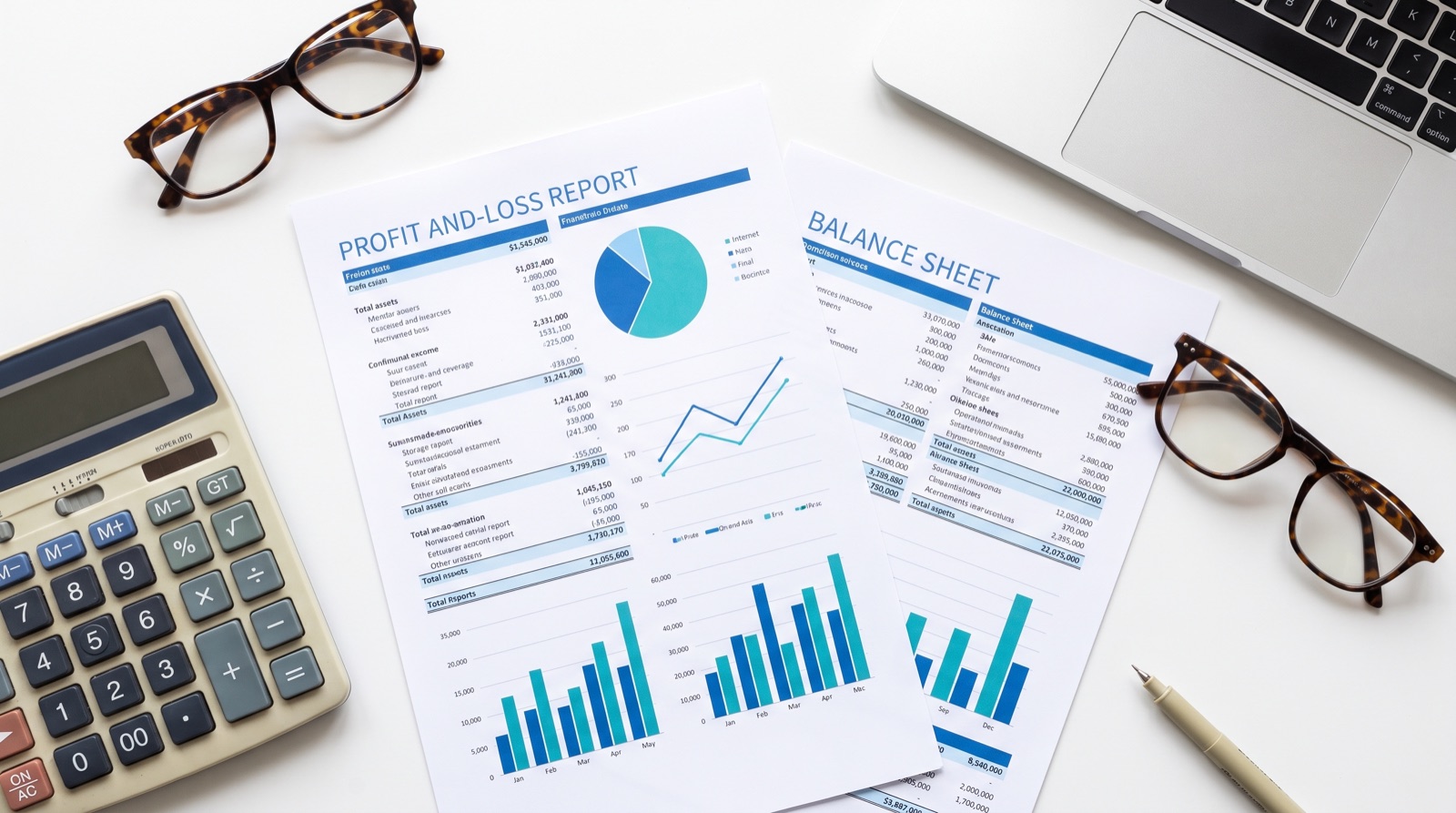 Profit-and-loss report and balance sheet with charts, a calculator and a laptop